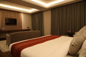 a hotel room with a bed and a flat screen tv at Casa Galwan in Leh