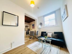 a living room with a couch and a table at Crouch End Garden Apartment! in London