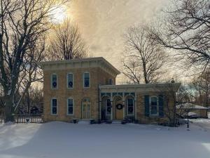 ein Backsteinhaus mit Schnee davor in der Unterkunft Restored historic home near ND and Amish Country in Granger