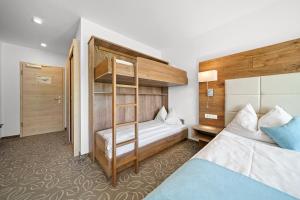 a bedroom with two beds and a bunk bed at Landhotel Berger in Eben im Pongau