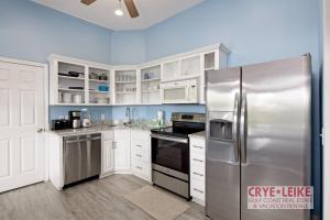 a kitchen with white cabinets and a stainless steel refrigerator at The Big Kahuna in Foley