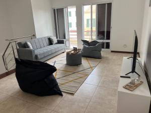 een woonkamer met een bank en een tv bij Populo Beach Villa in Livramento