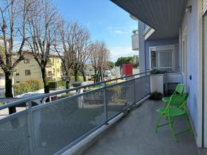 balkon z zielonym krzesłem na budynku w obiekcie Desenzanoloft The Wind Rose w mieście Desenzano del Garda
