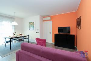 uma sala de estar com um sofá roxo e uma mesa em Desenzanoloft The Wind Rose em Desenzano del Garda