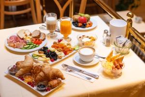 グリンデルワルトにあるHotel Grindelwalderhofの朝食用の食品とドリンクの盛り合わせが備わるテーブル