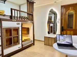 a room with bunk beds with a laptop on a table at Dorms Bui Vien - Walking street in Ho Chi Minh City