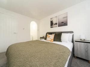una camera da letto con un grande letto e pareti bianche di Pass the Keys Spacious Wembley Apartment with Free Parking a Londra