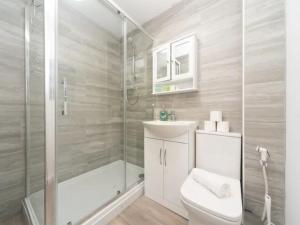 a bathroom with a shower and a toilet and a sink at Pass the Keys Spacious Wembley Apartment with Free Parking in London