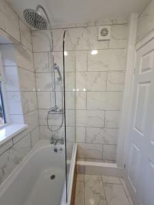 a bathroom with a shower with a bath tub at SleepyStays 3 Bedroom Modern & Central Location Sleeps 4 in Merthyr Tydfil