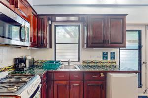 a kitchen with wooden cabinets and a sink at Condo #24 @ Beachside Villas in Placencia