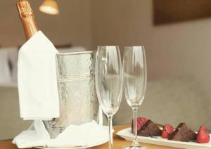 uma mesa com dois copos de vinho e uma garrafa de vinho em Pousada Cheverny - Fácil acesso ao centrinho e Baden Bar em Campos do Jordão