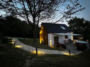 a small house with lights in front of it at Hiška pod črešnjo in Rogašovci