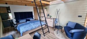 a bedroom with a bunk bed and a blue chair at Hiška pod črešnjo in Rogašovci