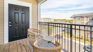 einen Balkon mit einer schwarzen Tür und einem Stuhl in der Unterkunft Landing Modern Apartment with Amazing Amenities (ID9174X16) in Fredericksburg