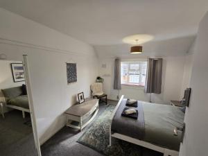 - une chambre avec un lit, un canapé et une chaise dans l'établissement Beautiful 4 bedroom house 7 minutes from Luton Airport, à Luton