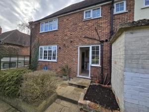 a brick house with a door and a yard at 4 Bedroom Home with Parking in Luton