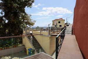 een loopbrug naar een gebouw met een balkon bij Villas Quinta da Lapa by AnaLodges in Câmara de Lobos