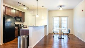cocina con mesa y nevera negra en Landing Modern Apartment with Amazing Amenities (ID7805X76), en Huntsville