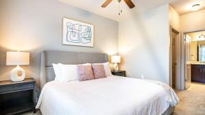 1 dormitorio con 1 cama blanca y 2 lámparas en Landing Modern Apartment with Amazing Amenities (ID7805X76), en Huntsville