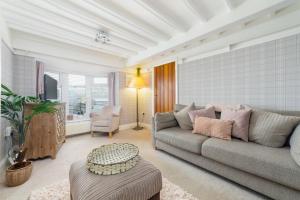 ein Wohnzimmer mit einem grauen Sofa und einem TV in der Unterkunft Seaview on the beach in Port Erin