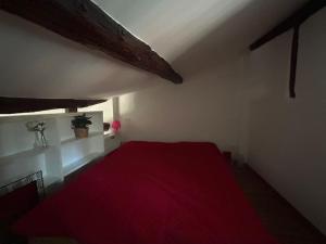 een slaapkamer met een rood bed en een rode deken bij Studio Cento3Cento - Holiday & Business Apartment in Bologna