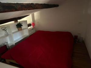 een slaapkamer met een rood bed en een rode deken bij Studio Cento3Cento - Holiday & Business Apartment in Bologna