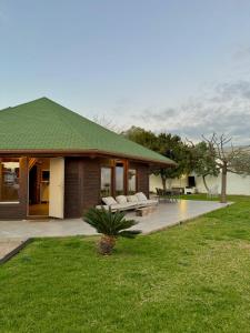 ein Haus mit einem grünen Dach und einer Terrasse in der Unterkunft Casita de madera in Benicarló