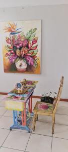 a room with a table and a chair and a painting at Residencial Brest Amazon Tarapoto in Tarapoto
