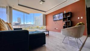 a living room with a couch and a tv at Edificio Tofino in Quito