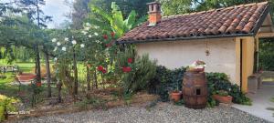 ogród z domem z kwiatami i beczką w obiekcie Il giardino di Marianna w mieście Novi Ligure