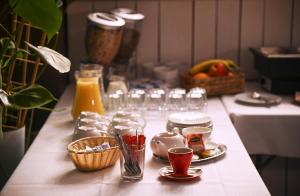 a table with glasses and plates of food and drinks at Garni Hotel Branč in Senica