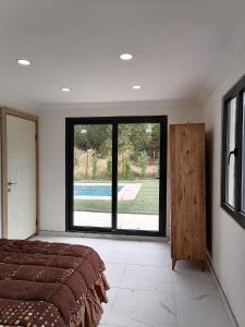 ein Schlafzimmer mit einem Bett und einem großen Fenster in der Unterkunft Nar Bahçesi in Çakırlar