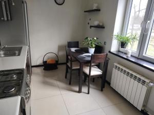 Una cocina con una mesa y sillas en una cocina. en U Zajączka, en Busko-Zdrój 7 fotos más