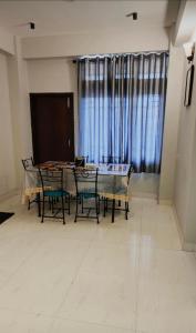 d'une salle à manger avec une table, des chaises et une fenêtre. dans l'établissement Vama Homes, à Guwahati