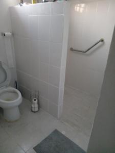 a white bathroom with a toilet and a shower at El rinconcito in Mérida