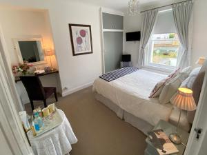 a bedroom with a bed and a desk and a window at Number 10 Bed & Breakfast in Keswick
