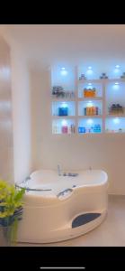 un lavabo blanco en una habitación con estanterías en Amala villas, en Arusha