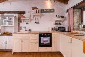 uma cozinha com armários brancos e um forno em Casa rural La alemana em Liérganes