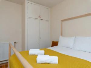 a bedroom with a yellow bed with two towels on it at Pass the Keys Spacious Murrayfield Flat in Edinburgh