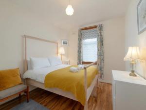 a bedroom with a bed and a chair and a window at Pass the Keys Spacious Murrayfield Flat in Edinburgh