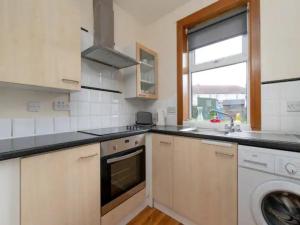 a kitchen with a sink and a washing machine at Pass the Keys Spacious Murrayfield Flat in Edinburgh