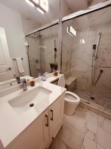 a bathroom with a sink and a toilet and a shower at Sweet home in Surrey