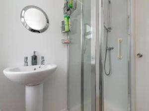 a bathroom with a sink and a shower with a mirror at Pass the Keys Spacious Murrayfield Flat in Edinburgh