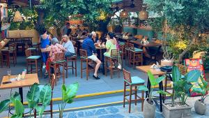 un gruppo di persone seduti ai tavoli in un ristorante di Hotel Kostis a Città di Skiathos