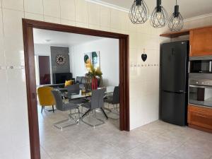 a kitchen and dining room with a table and chairs at Populo Beach Villa, Walk to Beach, Air Conditioning and Heating, near Ponta Delgada in Livramento +31 photos