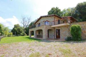 a large brick house with a balcony on top of it at Agriturismo Tenute di Hera - Via Francigena in Acquapendente