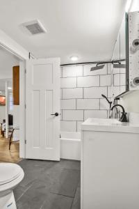 a bathroom with a toilet and a sink and a tub at BRAND NEW Private and Modern 2BR Unit in Minneapolis