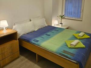 a bedroom with a bed with two towels on it at My Parents Guest House in Petrovec