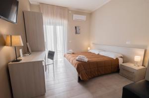 Cette chambre comprend un lit et un bureau avec une télévision. dans l'établissement Le Camere di Corte, à Sorbo Serpico