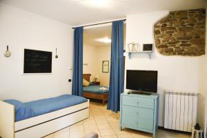 a small bedroom with a bed and a tv at A casa di Sole Brovello in Brovello-Carpugnino